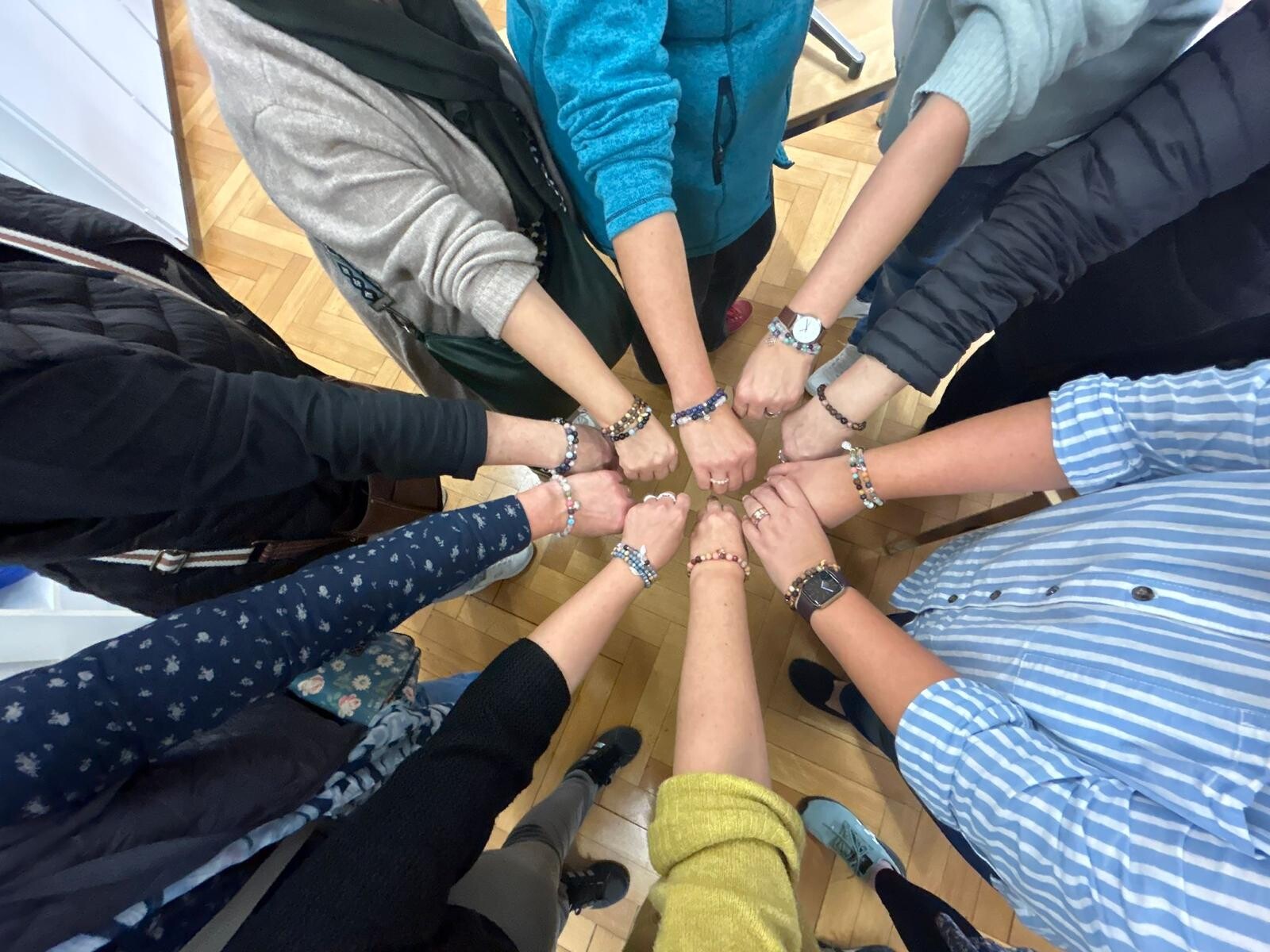 Ein Kreis aus Händen mit den selbst hergestellten Armbändern.